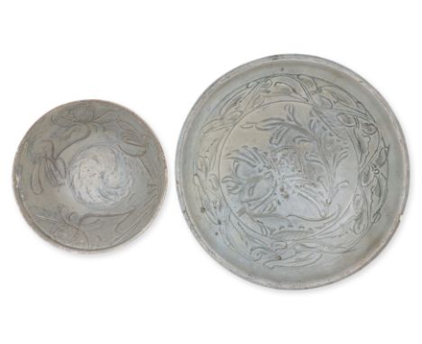 A CARVED CELADON CRANE BOWL AND A SMALLER FOLIATE BOWL
Song dynasty, a large shallow green glazed bowl with rounded overhangi