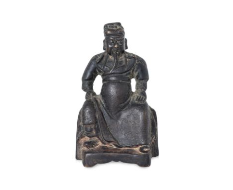 A SEATED BRONZE FIGURE OF GUANDI Ming dynasty, modelled wearing dragon decorated robe, sitting with legs apart and arms resti