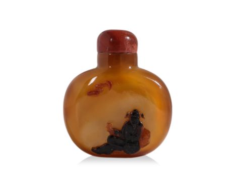 A CARVED CHALCEDONY SNUFF BOTTLE
Compressed oviform bottle in caramel tones, decorated in dark-brown relief carved scene of s