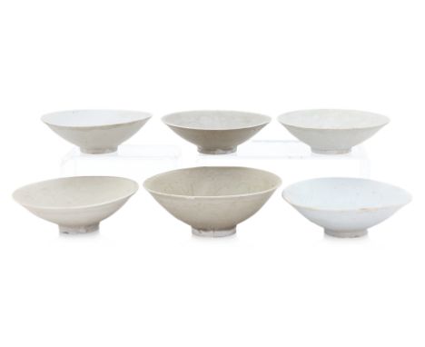 A GROUP OF SIX OLIVE-GLAZED AND CARVED BOWLS Yuan dynasty, with slightly rounded sides, and unglazed foot, various tones of o