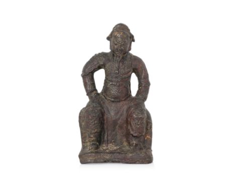 A LACQUERED BRONZE FIGURE OF GUANDI Ming dynasty, modelled wearing armour, sitting with legs apart, right fist clenched and l