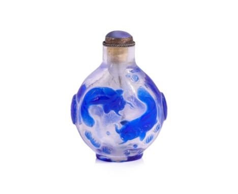A BLUE OVERLAY AND CLEAR GLASS SNUFF BOTTLE
Of oviform shape, decorated in relief carved dark-blue swimming koi fish among aq