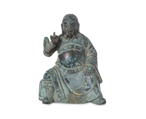 A SMALL SEATED BRONZE FIGURE OF GUANDI 17th/18th Century, modelled seated with legs apart, his right hand pointing upward and