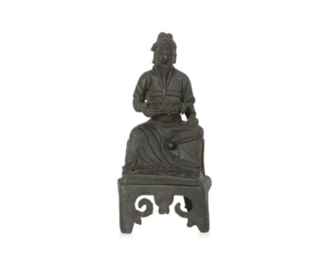 A SEATED BRONZE FIGURE OF GUANDI Ming dynasty, seated with left leg raised and right arm holding belt, wearing flowing robe d