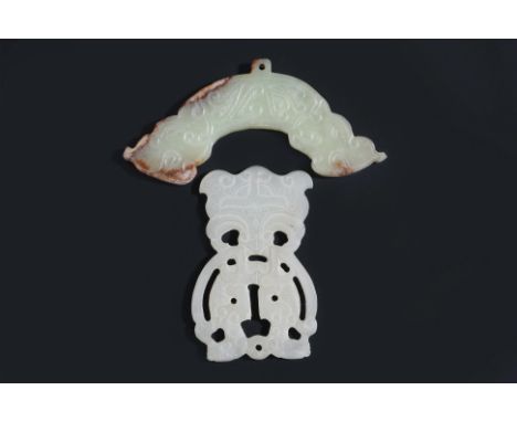 TWO CARVED JADE PENDANTS
An even-toned reticulated pendant of conjoined stylised dragons with archaistic mask below, and a ce