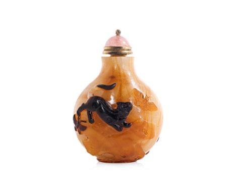AN AMBER AND OPAQUE WHITE GLASS RELIEF DECORATED SNUFF BOTTLE
19th Century, moon shaped bottle in transparent amber and swirl