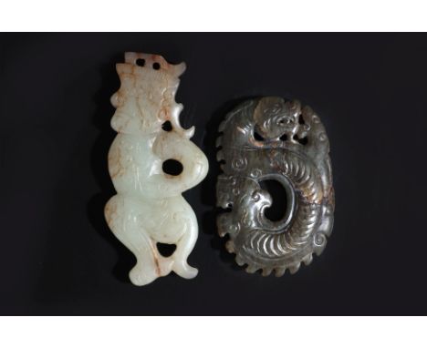 TWO JADE CARVINGS
An archaistic celadon and russet carving of a crouching male figure, and a dark green toned stylised dragon