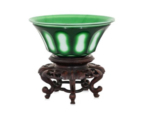 A PEKING OVERLAID GLASS BOWL
Early 20th Century, white opaque glass with green overlay, with facet cut decoration, on carved 