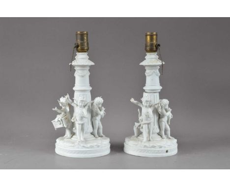 A pair of damaged parion wear ceramic lamp bases, with cherubs around the base, one damaged, AF, 33cm high (2)