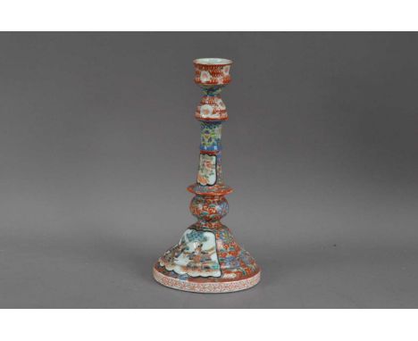 A 20th century Chinese porcelain candlestick, red floral design with panels of fighting soldiers, red character mark to the u