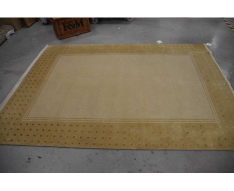 A modern woollen carpet, approx. 245cm x 178cm with beige ground and square design to border