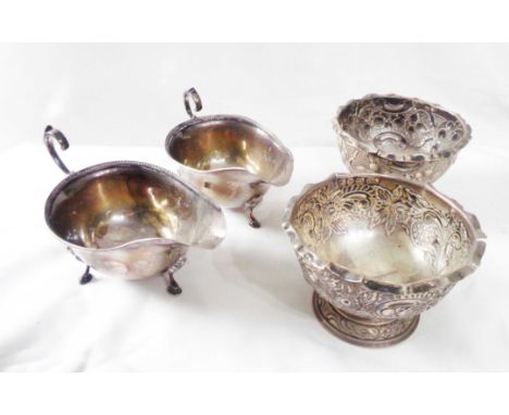 A pair of late Victorian silver pedestal table salts with embossed decoration - sold with a pair of small silver gravy boats 