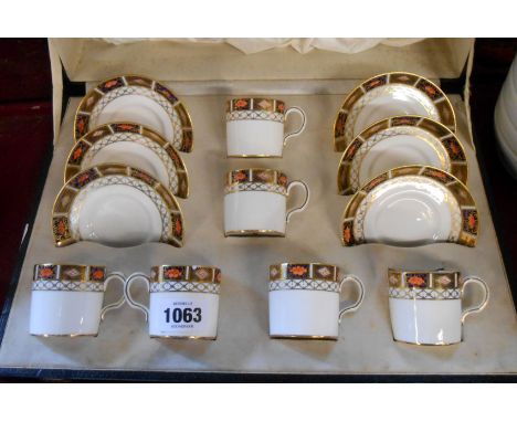 A Royal Crown Derby coffee set comprising six cans and saucers decorated with an Imari style border pattern, contained in ori