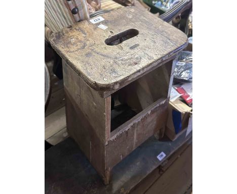A vintage mixed wood stool with carrying handle to seat - sold with an agricultural saw