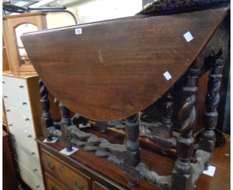 A 1.1m antique oak gateleg dining table, set on barley twist supports