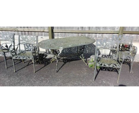 An oval pierced metal garden table and four chairs