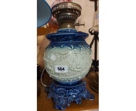 A vintage ceramic oil lamp base with moulded decoration, depicting a duck and dragonfly in a blue and white colourway