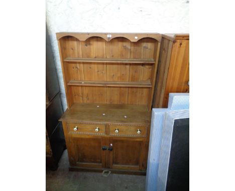 A 1.12m stained pine and oak two part dresser with two shelf open plate rack over an associated base with two drawers and dou