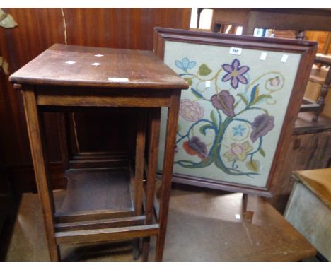 A vintage stained wood framed firescreen with floral woolwork panel under glass - sold with a vintage oak nest of three tea t