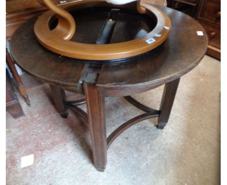 A 90cm diameter early 20th Century oak extending dining table with stowed leaves, set on moulded square supports and curved s