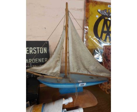 A small vintage blue Star brand pond yacht set on wooden stand