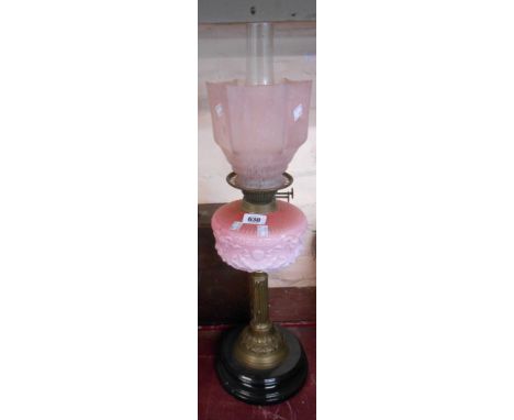A 19th Century oil lamp with opaque cranberry reservoir set on brass collumn and ceramic base, with chimny and associated sha