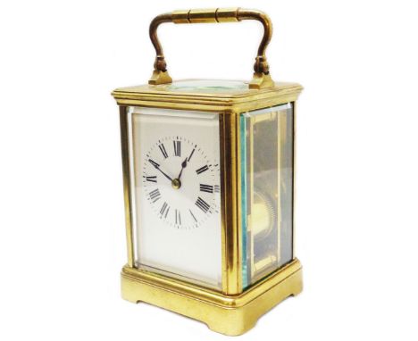 A vintage brass and bevelled glass cased carriage clock with Roman numerals and replacement platform escapement to the eight 