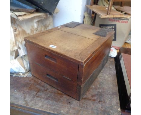 An Arts &amp; Crafts oak and hammered iron mounted lift-top coal box with heavy wing hinges, part clad sides and roller caste