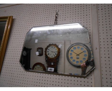 A vintage frameless wall mirror with shaped bevelled plate