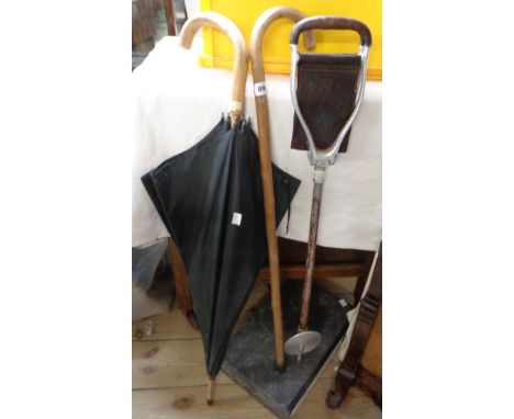 A vintage walking stick, an umbrella and an old shooting stick