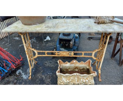 A marble topped table with decorative cast iron base