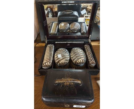 A vintage leather clad vanity box with fitted interior containing plated brushes and comb - sold with another small leather c