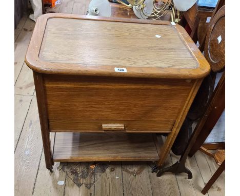 A vintage mixed wood sewing workbox/table by C. Arnold Ltd. with undertier and casters