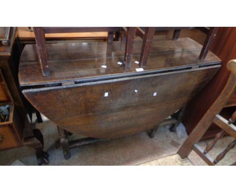 A 1.14m antique oak gateleg dining table, set on turned supports