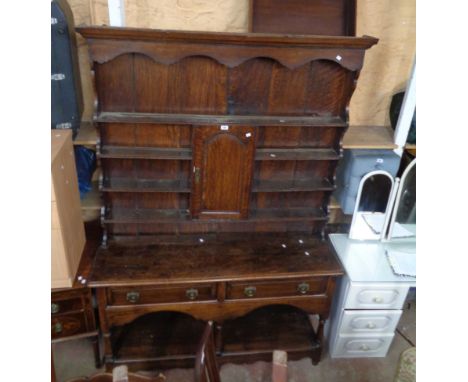 A 1.46m antique oak two part potboard dresser with central cupboard to the four shelf open plate rack over a base with two fr