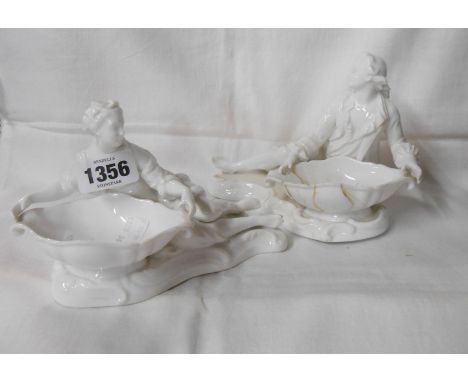 A pair of white glazed Continental porcelain figural table salts - various condition
