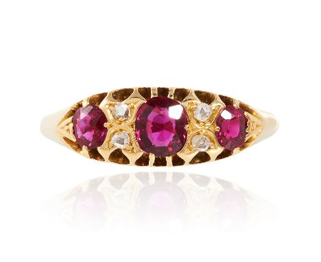 AN ANTIQUE RUBY AND DIAMOND DRESS RING in high carat yellow gold, set with three cushion cut rubies totalling approximately 0