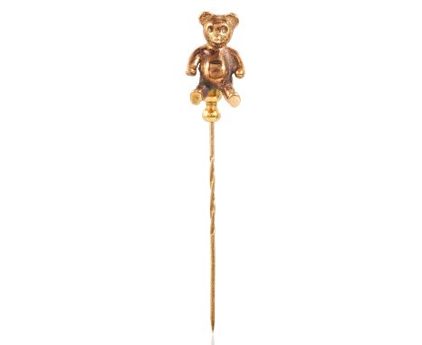 AN ANTIQUE TEDDY BEAR TIE / STICK PIN in yellow gold, the pin surmounted by a gold bear, apparently unmarked, 6.4cm, 6.2g.