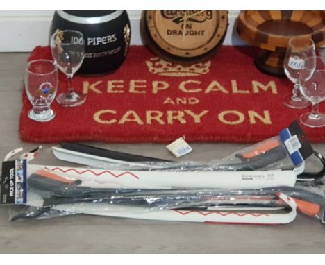 A keep calm and carry on door mat along with a 100 pipers scotch whiskey ice bucket carlsberg wall clock along with four drin