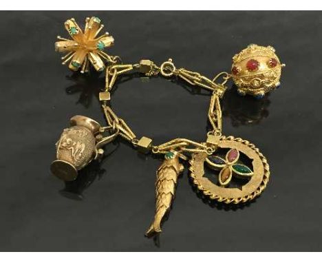 An 18ct gold fancy charm bracelet set with cabochon gemstones, 63.3g. CONDITION REPORT: The jug charm is 9ct gold, the chain 