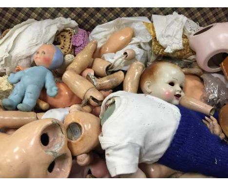 A trunk containing various vintage doll parts, bisque heads, limbs and clothing. (Q)