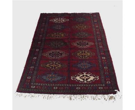 A wool Eastern carpet on red ground of geometric design, 77 cm x 122 cm.