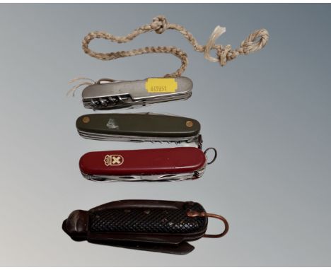 An Ogden's tobacco tin containing a vintage pocket knife and three Swiss army knives.