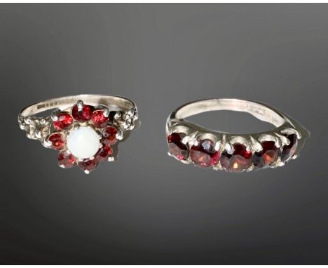 A silver opal and garnet cluster ring, together with a silver and garnet five-stone ring. (2)