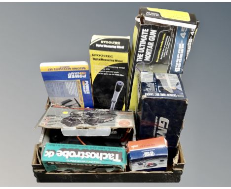 A box of assorted boxed tools including digital measuring wheel, Black &amp; Decker sander, timing light, welding accessory s