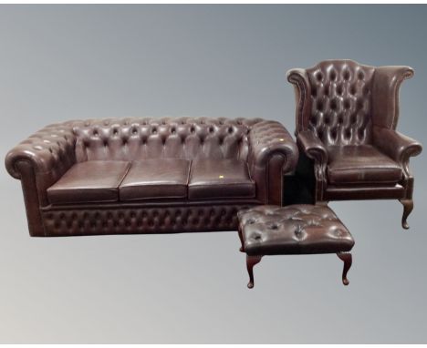 A brown button leather Chesterfield three seater settee with matching footstool and wingback armchair.