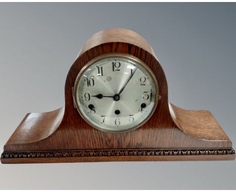 An Edwardian oak mantel clock with silvered dial.