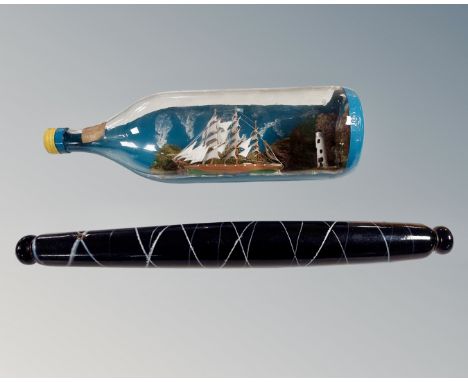 A Nailsea type antique glass rolling pin and a ship in bottle.