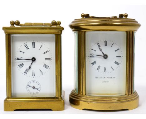 An oval brass carriage clock, retailed by Matthew Norman London; and another carriage clock with alarm (2)