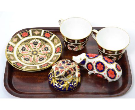 A Royal Crown Derby Imari frog paperweight, no stopper; another of a pig, silver stopper; and a pair of cups and saucers, pat